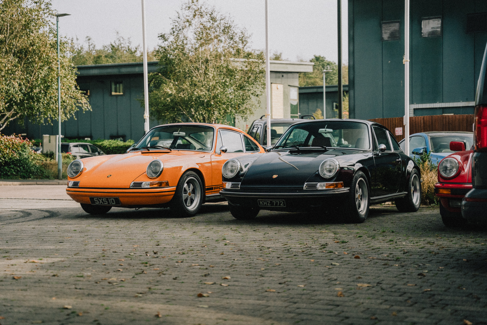 2 stunning 911 Rennsport cars parked outside their premises